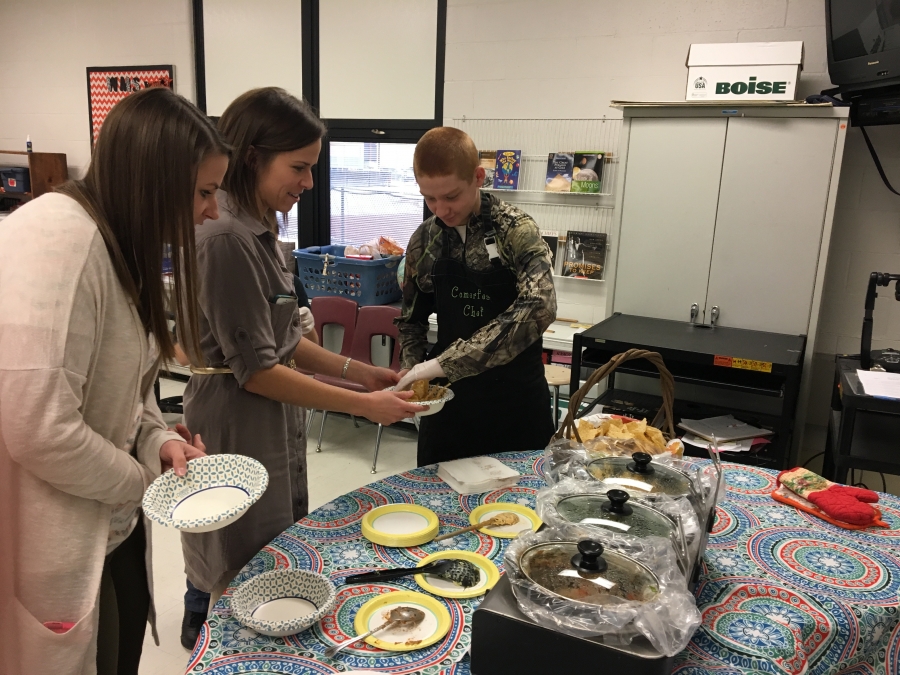 a boy serving women some chips